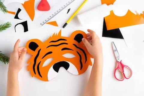 The process of making a children's New Year tiger mask with a child made of Stock Photos