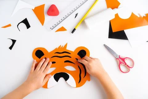 The process of making a children's New Year tiger mask with a child made of Stock Photos
