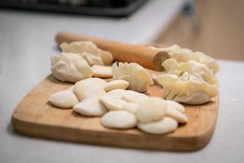 Process of making chinese dumplings. Raw dough and rolling pin on wooden ch.. Stock Photos