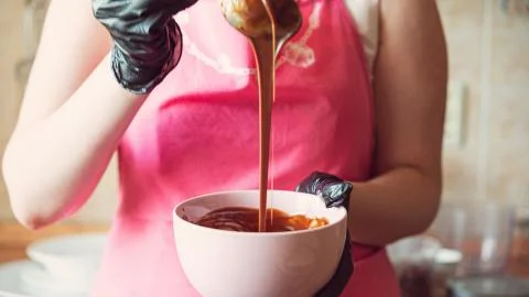 The process of making chocolate glaze, stirring with a spoon. Stock Photos