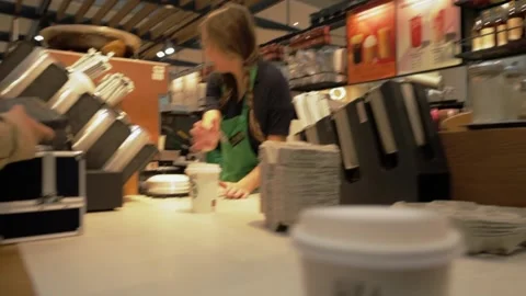 The process of making coffee in a coffee shop and delivering it to a client.  Video stock 220227275