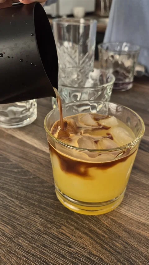 Process of making cold coffee with orange juice. Barista prepares cold black  Stock Footage 304740953