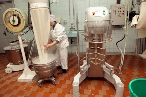 The process of making cookie dough in an industrial kneading machine at the f Stock Photos