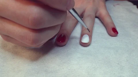 The process of making delicate design on nails. Nail beautician hand painting Stock Footage 88908698