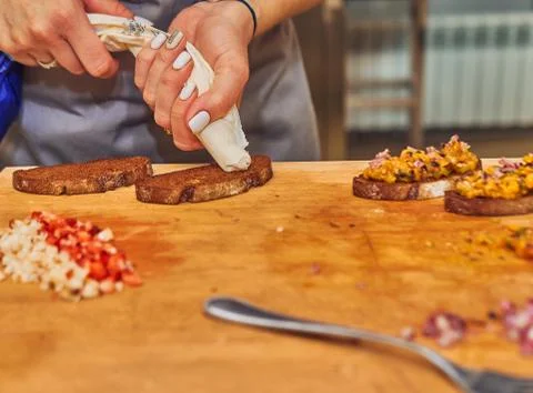 The process of making delicious bruschetta on crispy toasted bread. Female ha Foto stock