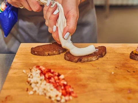 The process of making delicious bruschetta on crispy toasted bread. Female ha Stock-Fotos