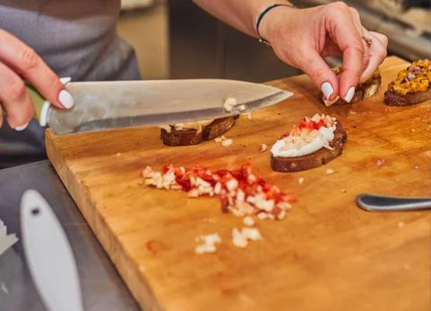 The process of making delicious bruschetta on crispy toasted bread. Female ha Stock-Fotos