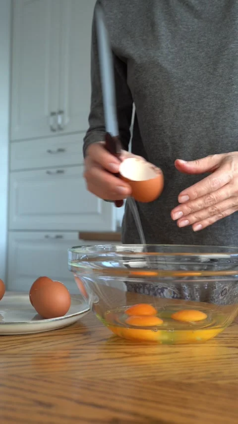 The process of making the dough., dough, omelette, eggnog. A woman breaks Stock Footage 312378760
