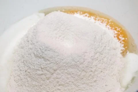The process of making dough. Flour and eggs in a bowl. Stock Photos