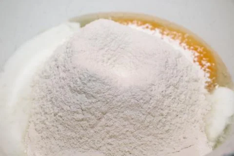 The process of making dough. Flour and eggs in a bowl. Stock Photos
