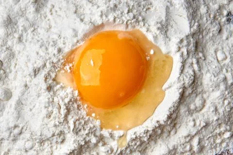 The process of making dough. Ingredients: wheat flour and broken chicken egg. Stock-Fotos
