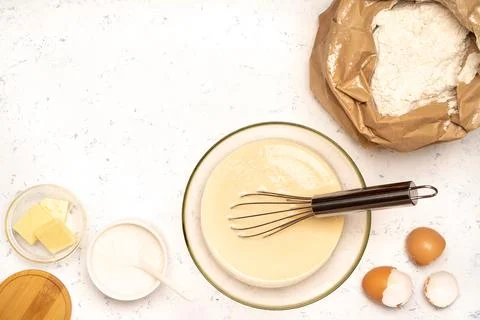 The process of making dough for pancakes with ingredients on a light table, e Stock Photos