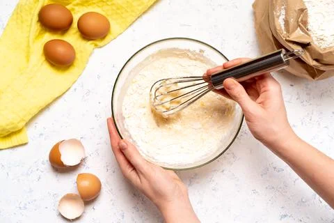 The process of making dough for pancakes with ingredients on a light table, e Stock Photos