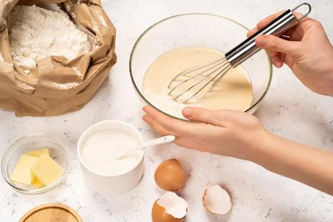 The process of making dough for pancakes with ingredients on a light table, eggs Stock Photos
