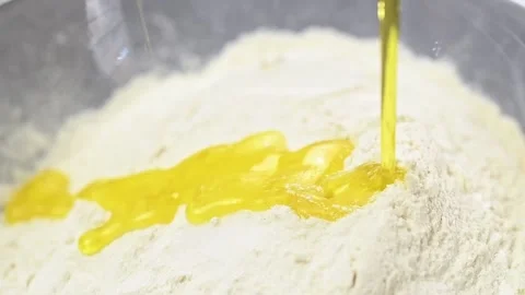 Process of making dough. Pouring of olive oil into a glass bowl with flour. 스톡 동영상 151045586
