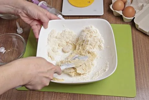 Process of making dough. Woman mixed powdered sugar, almond flour and egg white Stock Photos