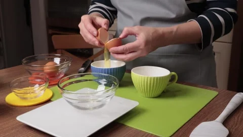 Process of making dough. Woman separates egg white from yolk in kitchen. Scales Stock Footage 286829522