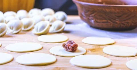 The process of making dumplings. Dumplings - Russian on a wooden background. Stock Photos