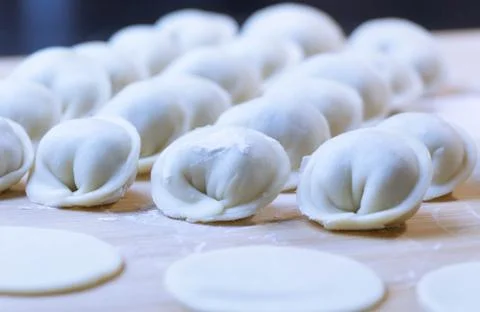 The process of making dumplings. Dumplings - Russian on a wooden background. Stock Photos