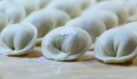 The process of making dumplings. Dumplings - Russian on a wooden background. Stock Photos