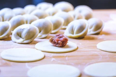 The process of making dumplings. Dumplings - Russian on a wooden background. Stock Photos