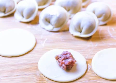 The process of making dumplings. Dumplings - Russian on a wooden background. Stock Photos
