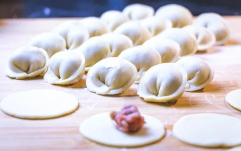 The process of making dumplings. Dumplings - Russian on a wooden background. Stock Photos