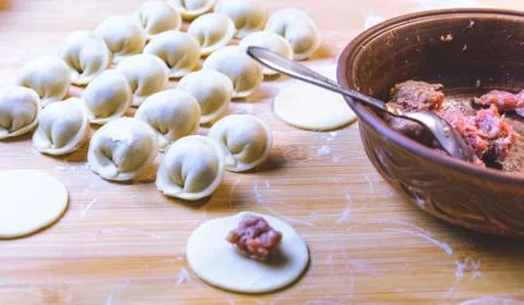 The process of making dumplings. Dumplings - Russian on a wooden background. Stock Photos