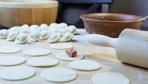 The process of making dumplings. Dumplings - Russian on a wooden background. Stock Photos