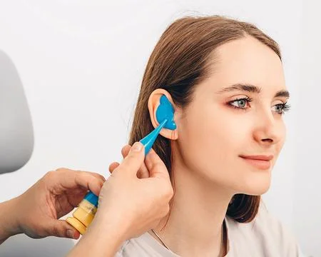 Process of making earplugs from an impression of an individual human ear. Ear Fotos Stock