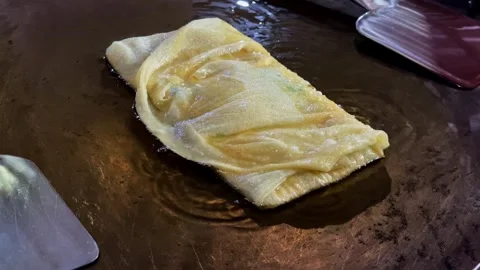 The process of making egg martabak of "Martabak Telur" is fried in a flat Stock Footage 279799489