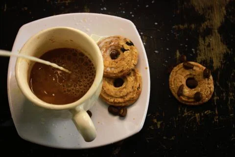 The process of making flat white coffee by pouring steam milk into a cup of e Stock Photos