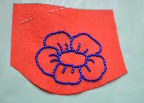 Process of making a flower beaded brooch - contour on felt embroided with blue Stock Photos