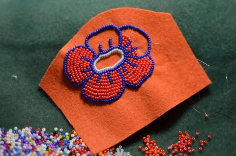 Process of making a flower beaded brooch - master class - embroidery with red Stock Photos
