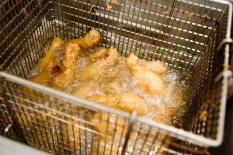 Process of making fried chicken on the kitchen. Restaurant, cafe or pizzeria  Stock Photos