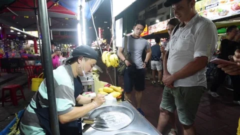 Process of making fried fruit ice-cream dessert by street vendor Stock Footage 76852374