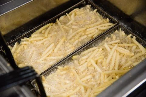 Process of making fried potato on the kitchen. Restaurant, cafe or pizzeria c Stock Photos