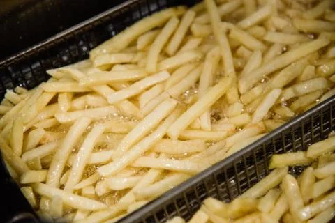 Process of making fried potato on the kitchen. Restaurant, cafe or pizzeria c Stock Photos