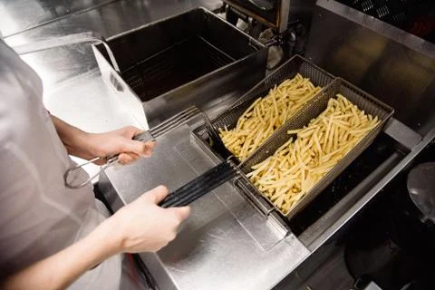 Process of making fried potato on the kitchen. Restaurant, cafe or pizzeria c Stock Photos