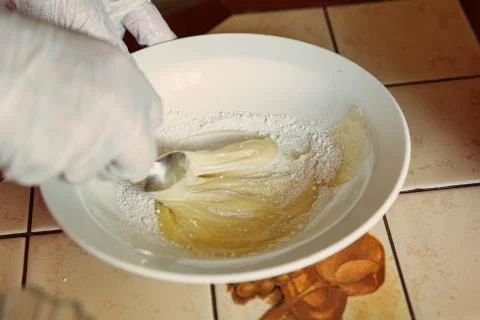 The process of making frosting for a mousse cake. The girl mixes the icing in Stock Photos