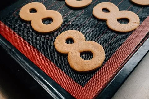 The process of making gingerbread for March 8. Cut out figure eights from dough 스톡 사진