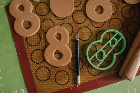 The process of making gingerbread for March 8. Cut out figure eights from dough 스톡 사진