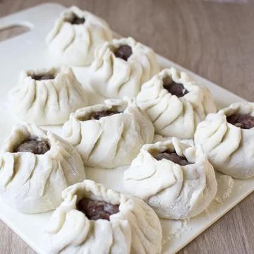 The process of making home-made dumplings. Raw homemade dumplings on a wooden Stock Photos