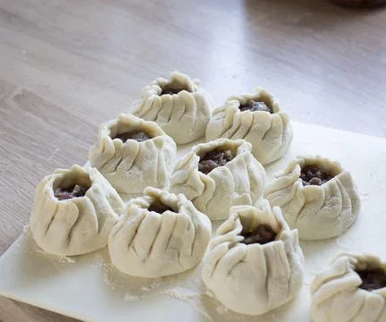 The process of making home-made dumplings. Raw homemade dumplings on a wooden Stock Photos