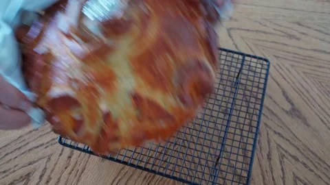 The process making homemade bread. baker puts baked loaf of bread on a stand to Stock Footage 204856106