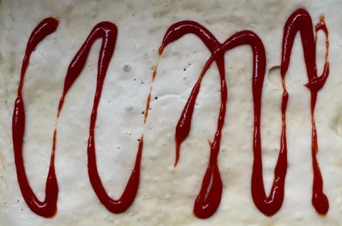 The process of making homemade pizza with your own hands. Dough with ketchup. Stock Photos