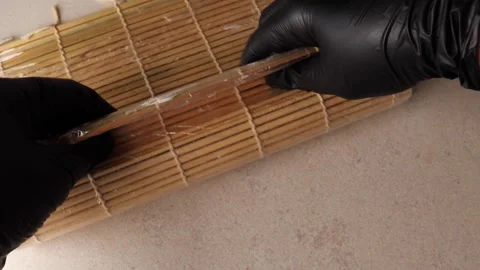 The process of making homemade sushi rolls. Hands in black silicone gloves Stock Footage 278988642