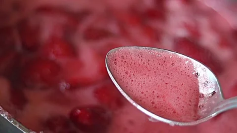 The process of making jam. remove the foam from the boiling strawberries. Stock Footage 244940069