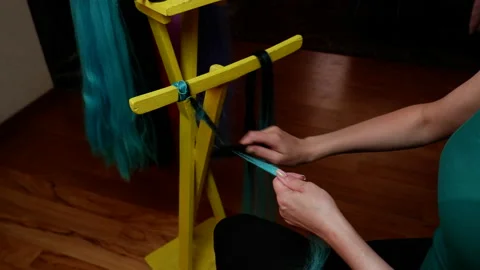 The process of making kanekalon dreadlocks. Female hands are combing the kane Stock Footage 155308003