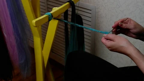 The process of making kanekalon dreadlocks. Women's hands are crocheted throu Stock Footage 155307849